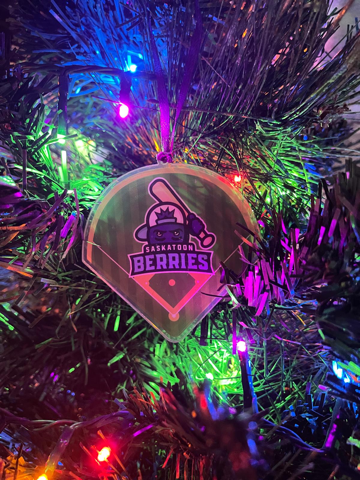 Decorative ornament with 'Saskatoon Berries' logo on a Christmas tree with lights.